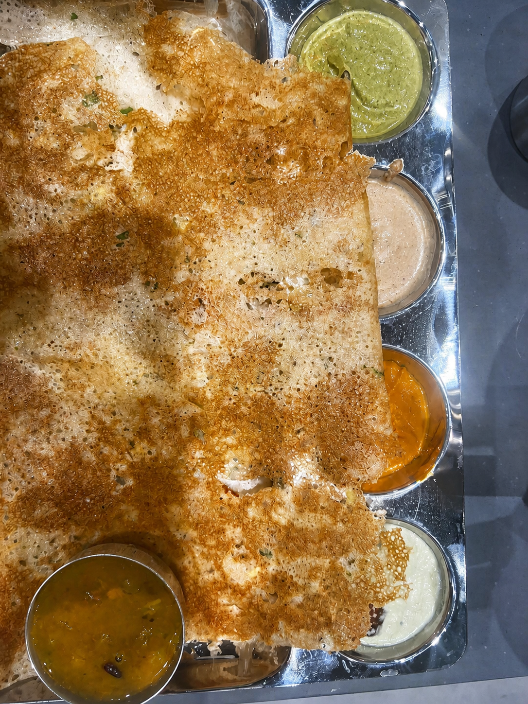 A shared table dish with small bowls of accompaniments